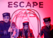 Personagens fantasiados em parede com logo do Escape Hotel