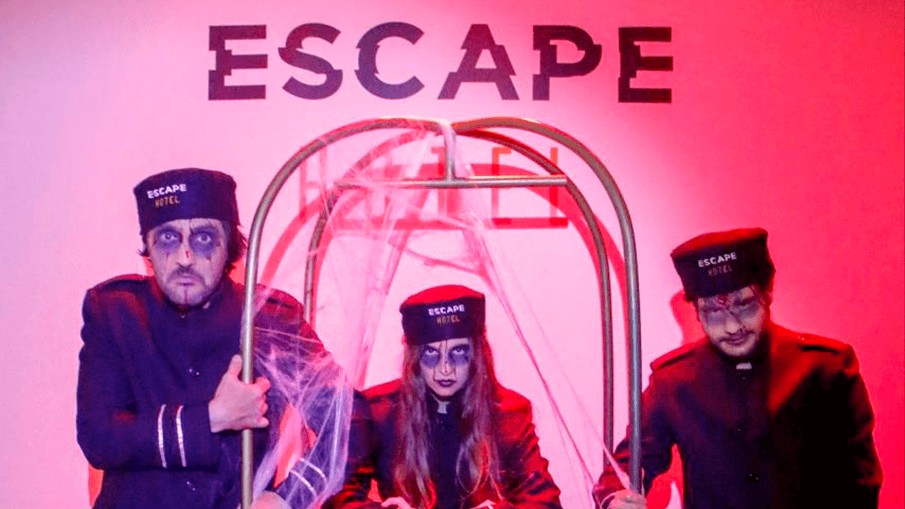 Personagens fantasiados em parede com logo do Escape Hotel